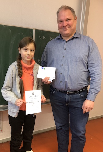 Schulleiter Müller und Theresa mit Urkunde und Gutschein